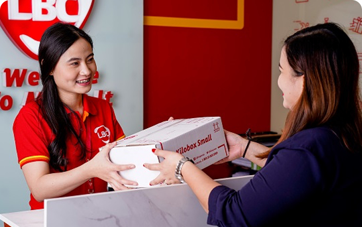 woman dropping off package to a female LBC employee