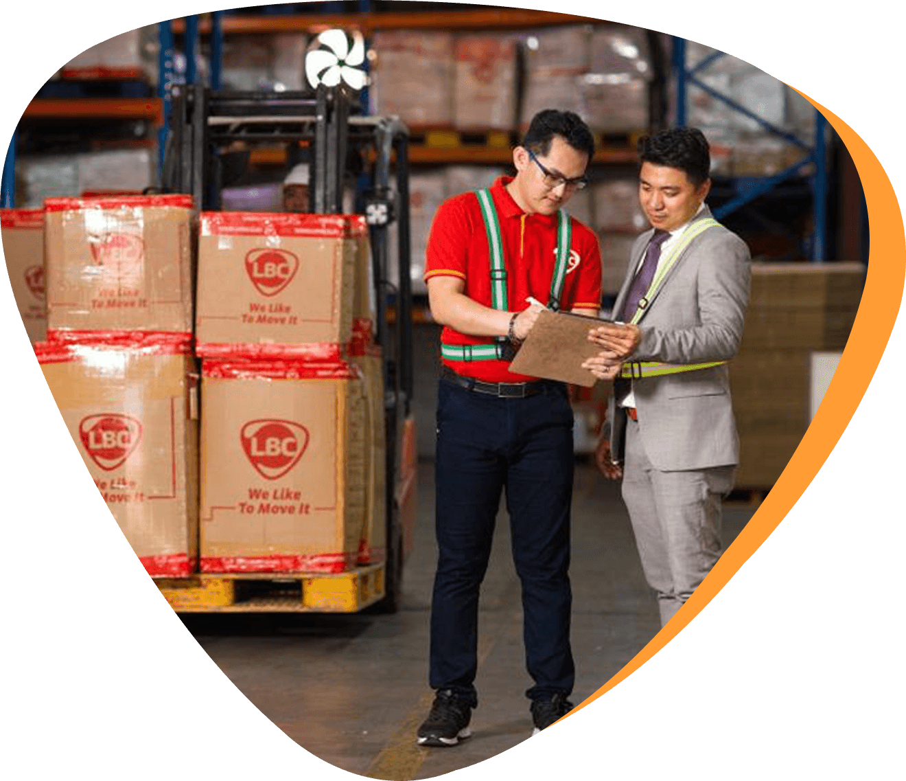 an LBC employee and a businessman talking inside a warehouse